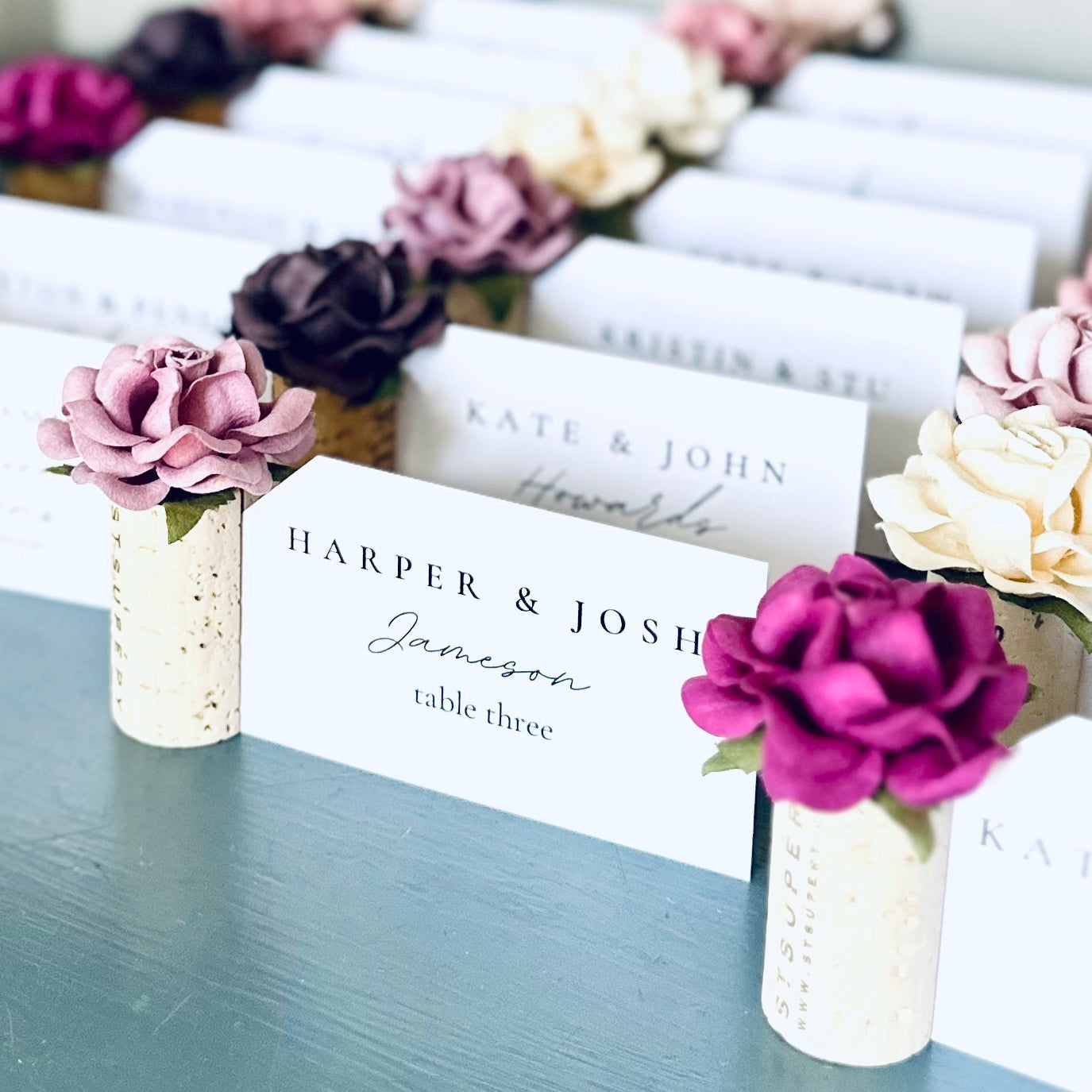 Table name cards with floral place card holders holders on a blue table