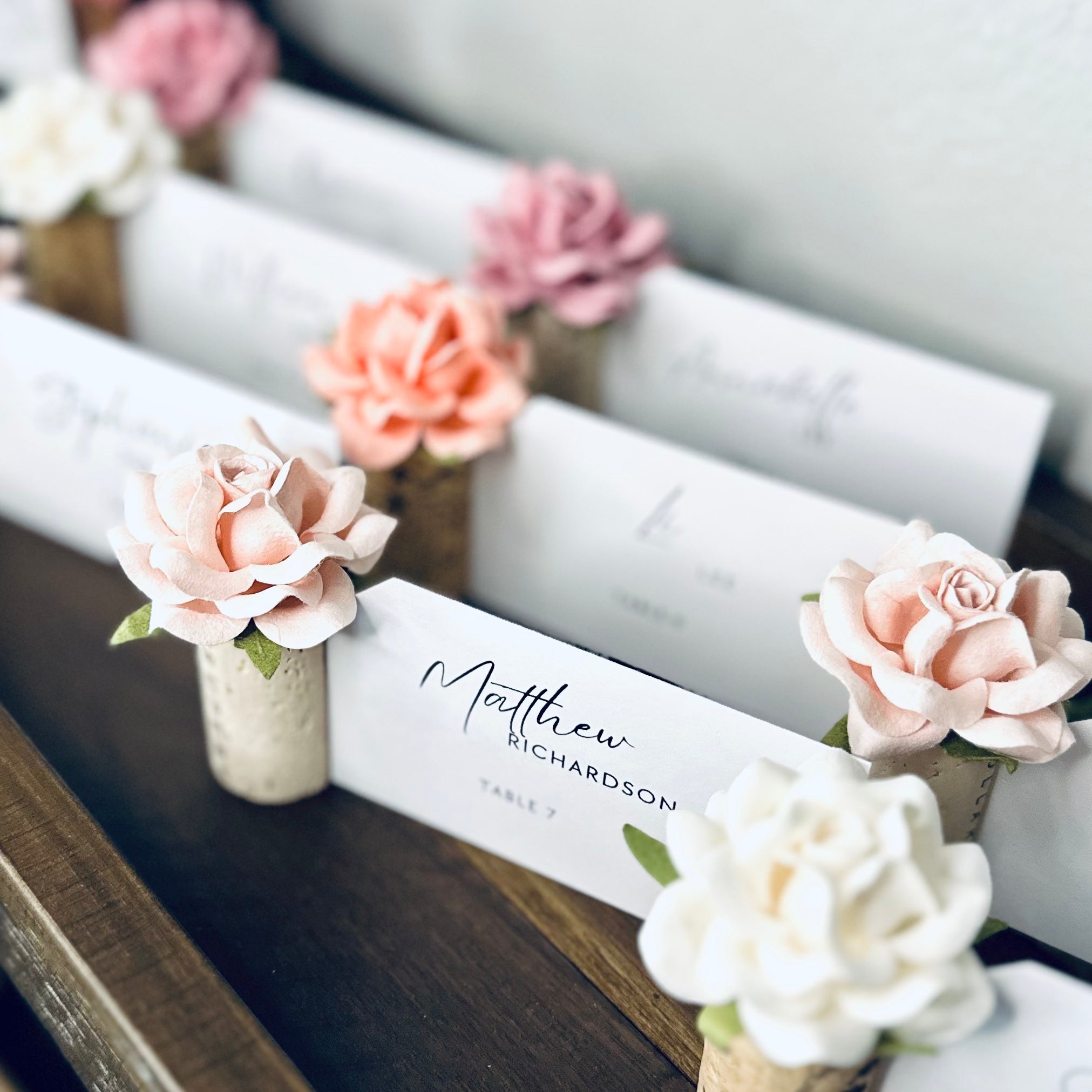 Decorative name card with floral elements on a wooden surface