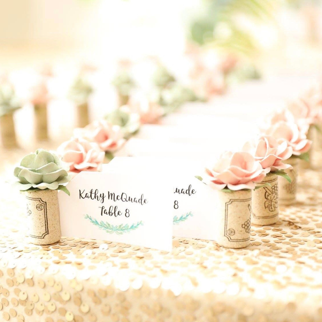 a wedding place card table with printed guest name cards and table assignments in shades of blush pink and mint green.