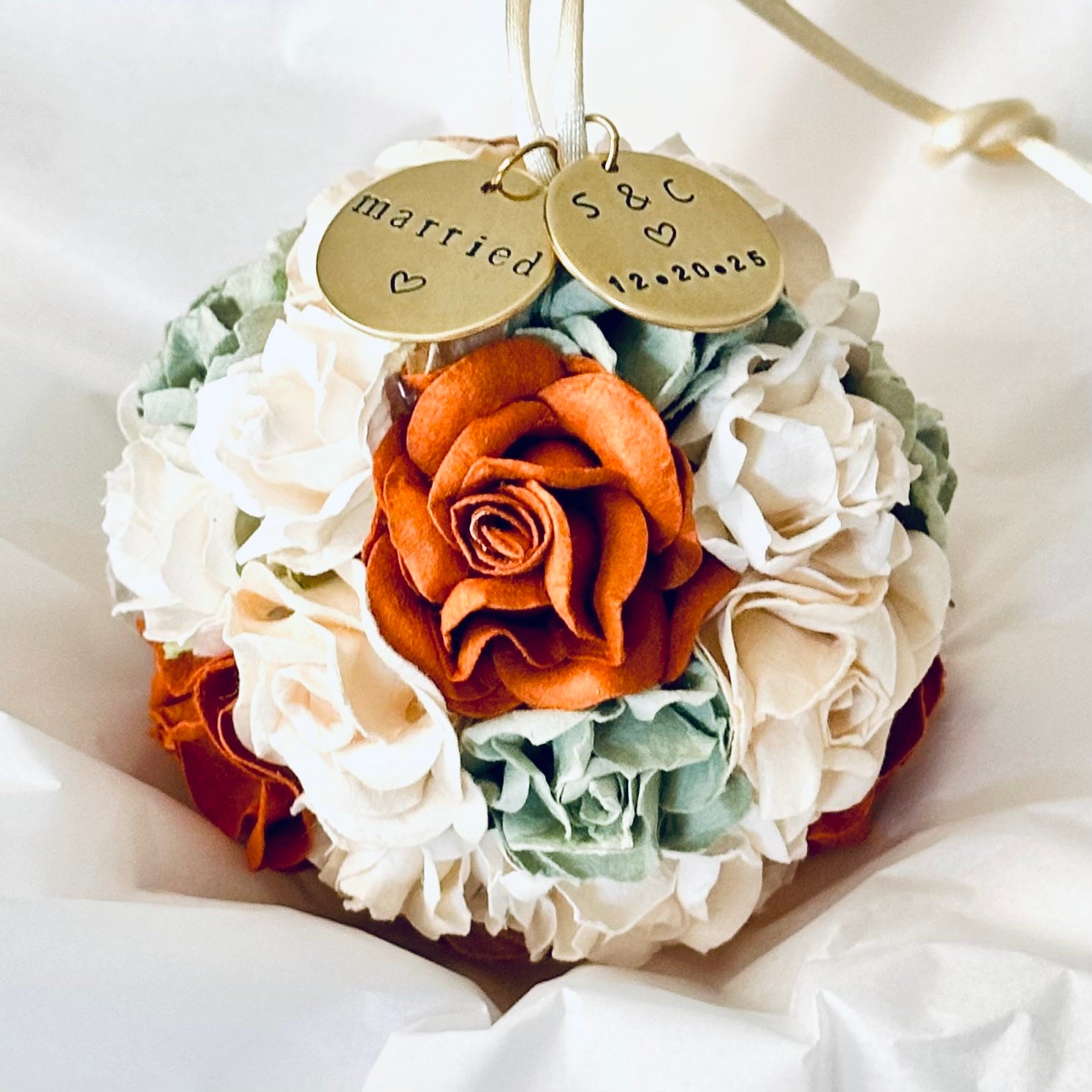 Custom wedding ornament made of paper flowers in shades of rust, terra cotta, ivory, white, and sage.  Two personalized charms read "married" and a couples' initials and wedding date.