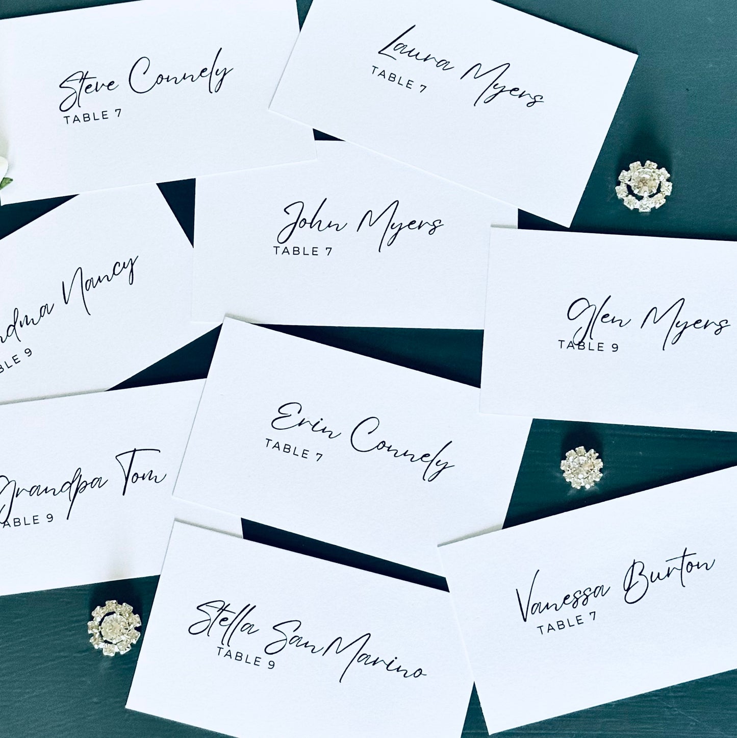 Personalized guest name cards on a dark surface with decorative elements.