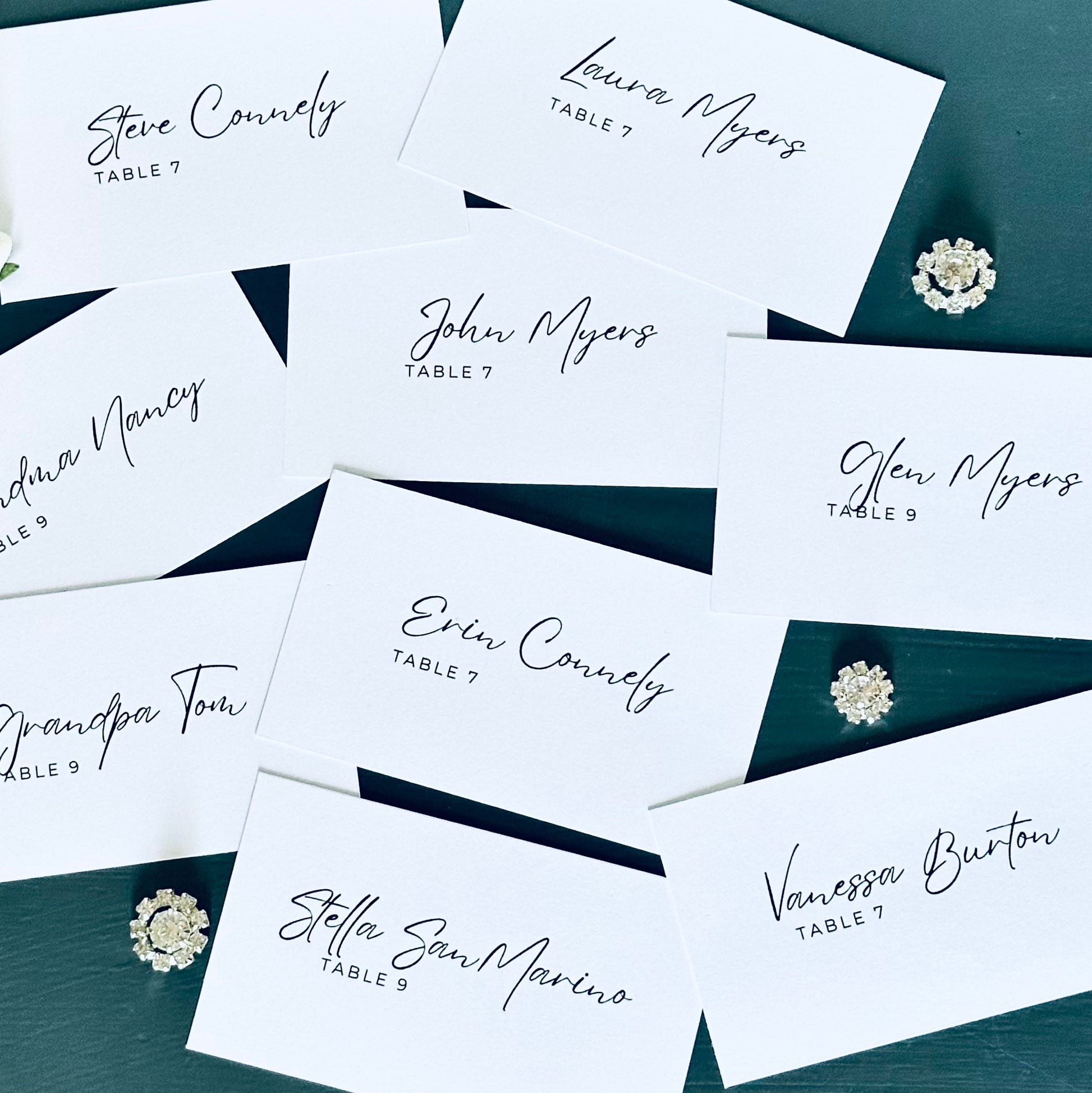 Personalized guest name cards on a dark surface with decorative elements.